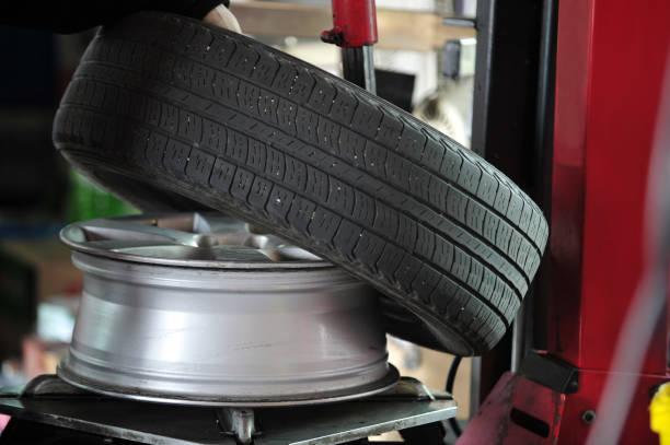 in der KFZ Werkstatt wird auf der Reifenmontiermaschine ein Reifen abmontiert.